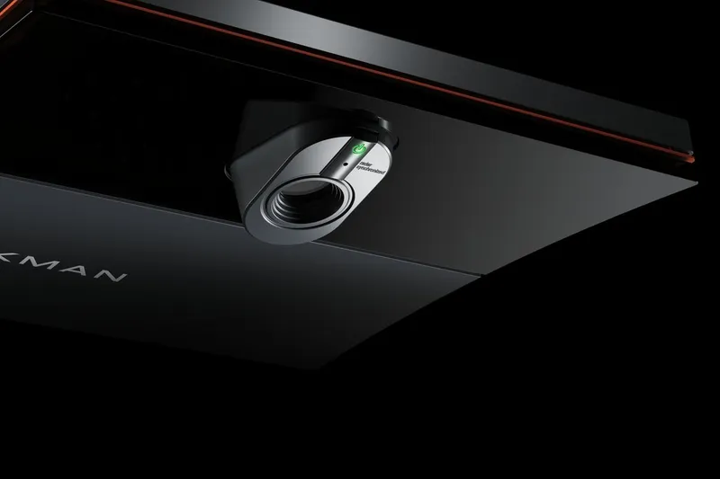 Close-up of a TrackMan launch monitor and ball-flight data rendered as glowing light traces.