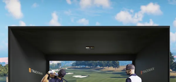 Lively private-event atmosphere inside a Swing Spot golf bay, silhouettes gathered around the screen.
